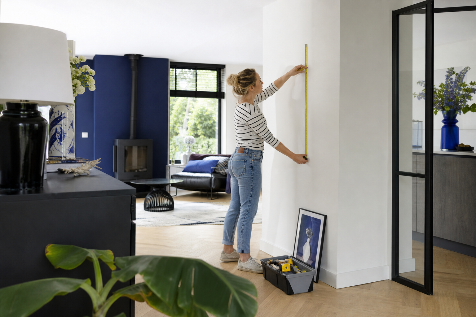 Bewoner meet een lichte binnenmuur in een ruim huis met blauwe accenten